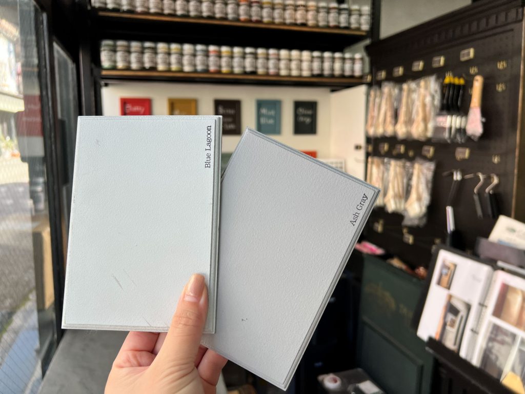 外壁に近いアッシュグレー(Ash Gray)と比較しながら、仕上がりのイメージを確認している様子。